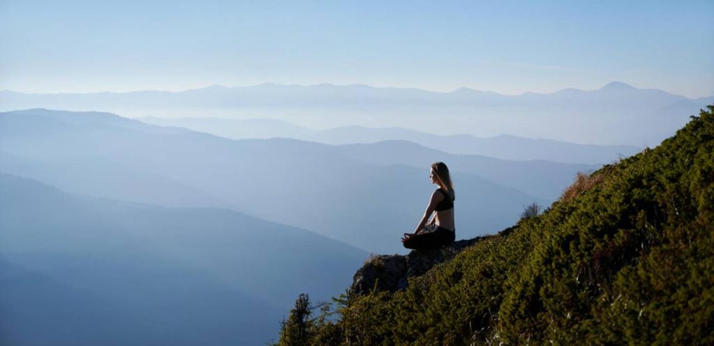 Mulher meditando em uma montanha